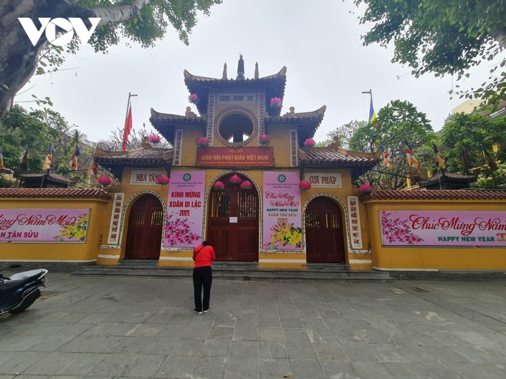 A tranquil scene outside of Quan Su pagoda with only one worshipper present A tranquil scene outside of Quan Su pagoda with only one worshipper present