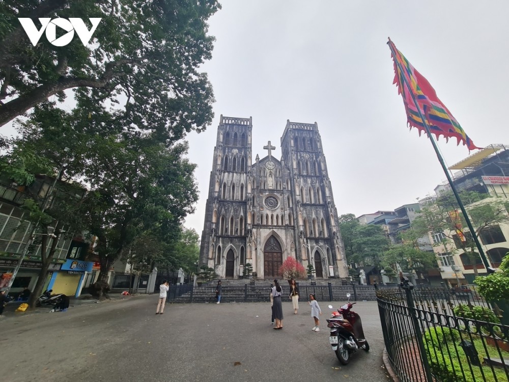 A few locals take photos in front of St. Joseph's Cathedral despite its closure due to the COVID-19 epidemic.