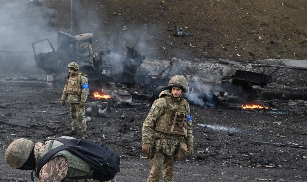 Các thành viên quân đội Ukraine tìm kiếm và thu thập các quả đạn chưa nổ sau cuộc giao tranh với nhóm đột kích của Nga ở thủ đô Kyiv của Ukraine.. AFP)