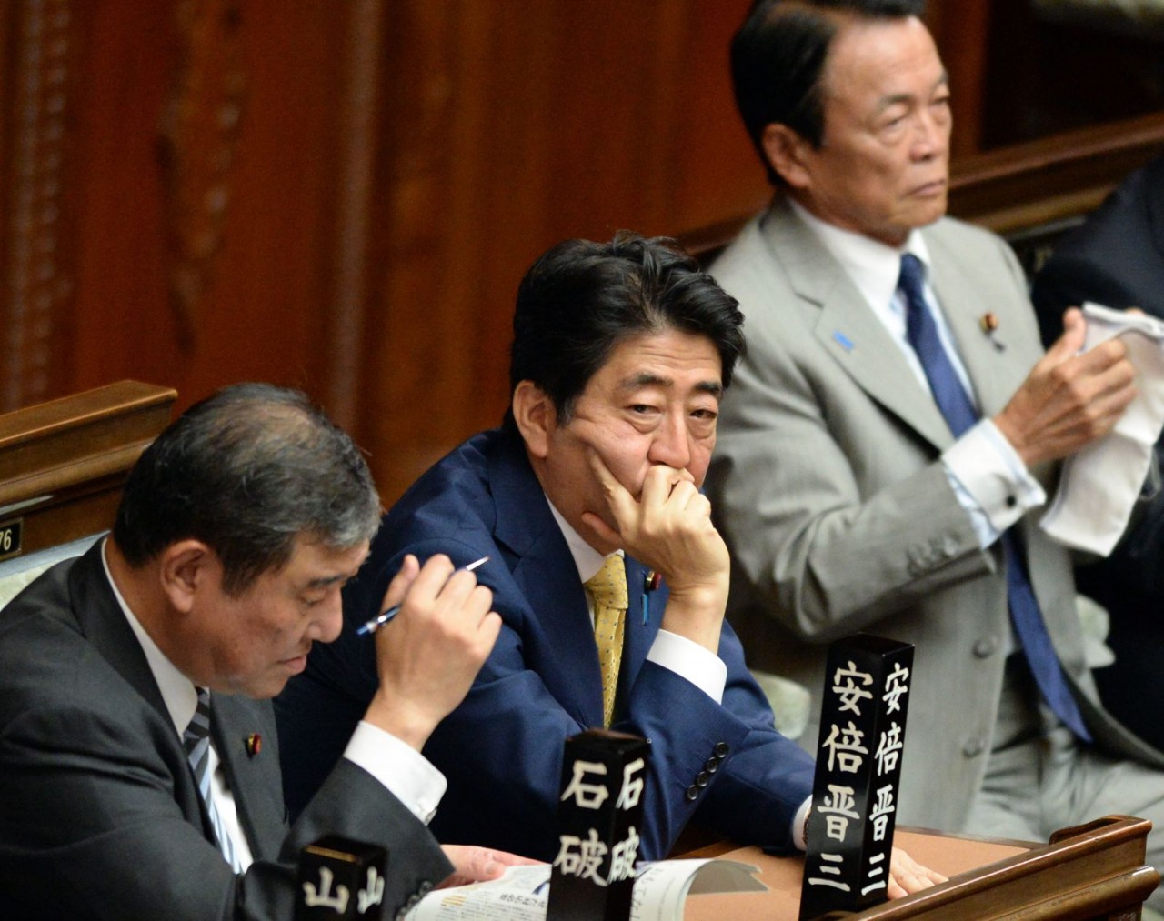 Thủ tướng Abe lắng nghe tuyên bố của các nhà lập pháp đối lập tại Tokyo vào năm 2015. Liên minh cầm quyền của Nhật Bản thông qua một loạt dự luật an ninh gây tranh cãi, đánh dấu sự đảo lộn quan trọng nhất của thế trận quốc phòng "thuần túy phòng thủ" của 