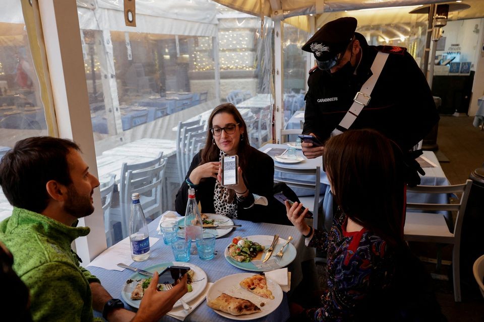 Kiểm tra thẻ xanh Covid-19 với thực khách tại một nhà hàng ở Naples, Italy ngày 6/12/2021. (Nguồn: Reuters)
