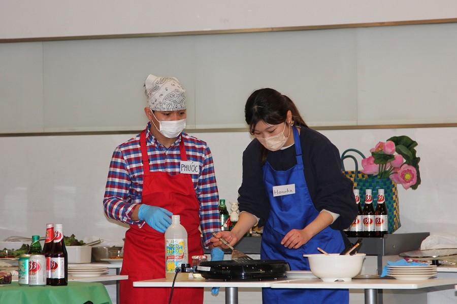 Hai thí sinh Việt Nam và Nhật Bản tại cuộc thi làm bánh xèo. (Nguồn: TTXVN)