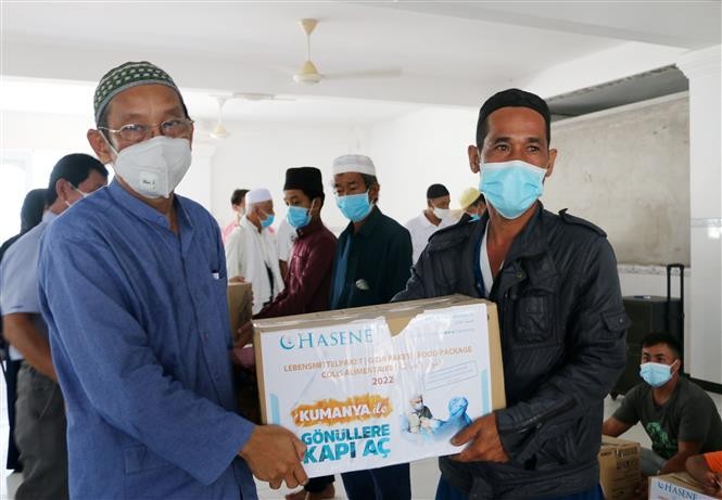 Ông Haji Jacky, Trưởng Ban Đại diện cộng đồng Hồi giáo Islam tỉnh An Giang (bìa trái) tặng quà cho các hộ gia đình người Chăm có hoàn cảnh khó khăn trên địa bàn xã Đa Phước. (Nguồn: TTXVN)