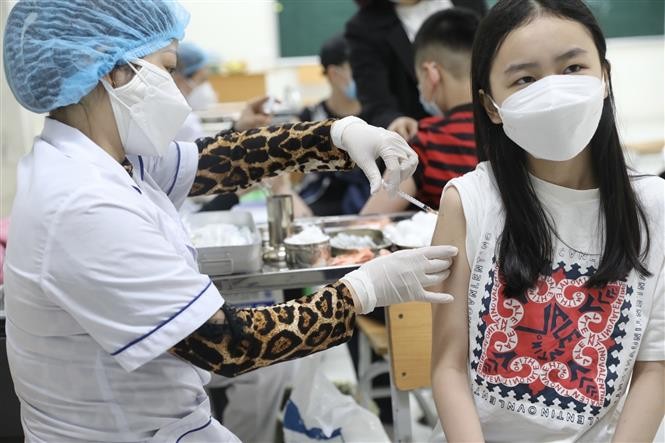 Nhân viên y tế tiêm vaccine phòng COVID-19 cho học sinh lớp 6 tại điểm tiêm chủng trường THCS Lê Ngọc Hân (quận Hai Bà Trưng, Hà Nội) sáng 17/4. (Nguồn: TTXVN)