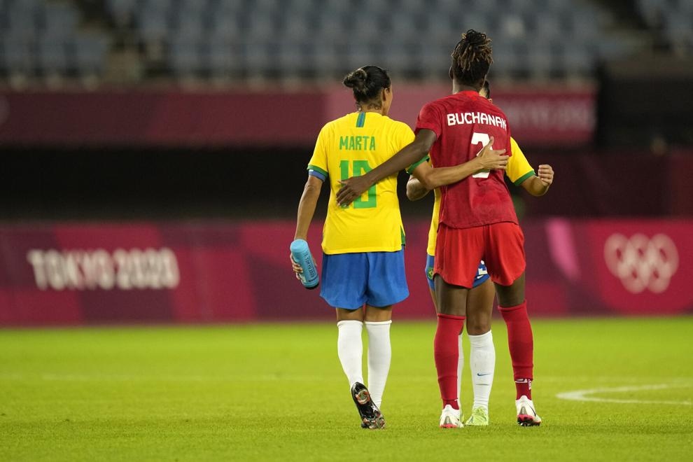Vòng tay tình bạn giữa Kadeisha Buchanan (Canada) và Marta (Brazil) sau tiếng còi kết thúc trận đấu tứ kết bóng đá nữ tại Rifu, Nhật Bản ngày 30/7. Canada thắng 4-3 trong loạt sút luân lưu. (Nguồn: AP)