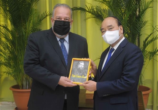 Chủ tịch nước Nguyễn Xuân Phúc tặng Thủ tướng Cuba Manuel Marrero Cruz cuốn sách “Fidel Castro Ruz Nhà Cách mạng Quốc tế vĩ đại”. (Nguồn: TTXVN)