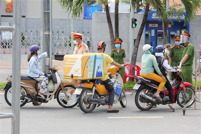 Lực lượng chức năng kiểm tra Giấy đi đường của người dân khi qua các chốt kiểm soát phòng chống dịch COVID-19. (Nguồn: TTXVN)