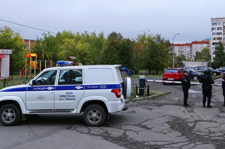 Một phụ nữ nói chuyện với các sĩ quan cảnh sát đang bảo vệ an ninh khu vực sau một vụ xả súng ở trường học ở Izhevsk, Nga. (Nguồn: Reuters)