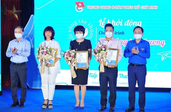 Đồng chí Nguyễn Anh Tuấn, Bí thư thứ nhất Trung ương Đoàn trao thư cảm ơn cho các đơn vị đồng hành cùng chương trình cộng đồng “Nối vòng tay thương”, ngày 3/10. (Nguồn: TTXVN)