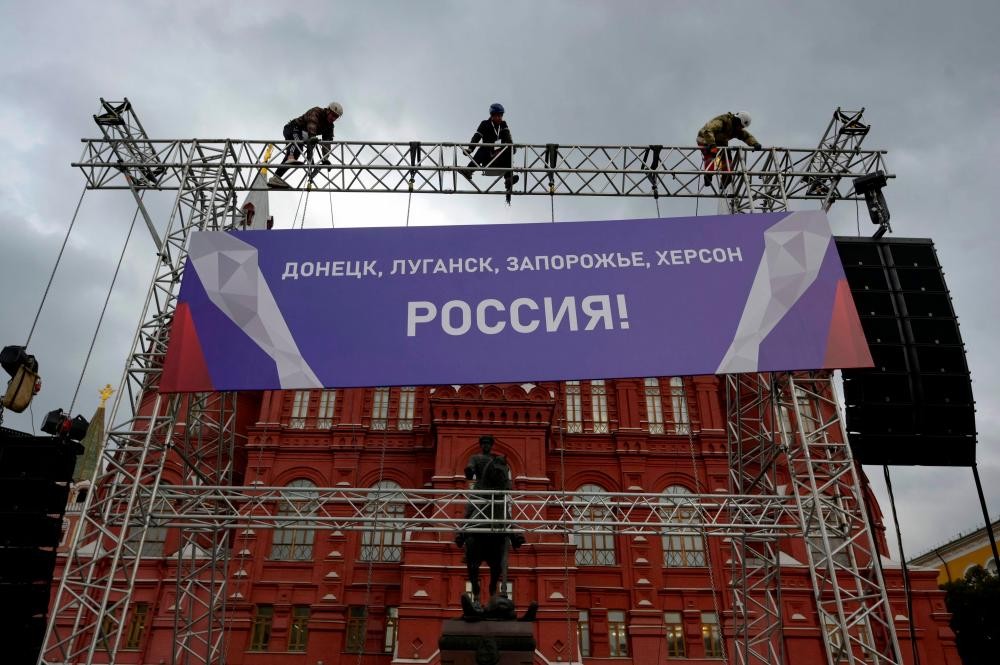Công nhân sửa một biểu ngữ có nội dung “Donetsk, Lugansk, Zaporizhzhia, Kherson - Nga!” của một công trình được lắp đặt trước Bảo tàng Lịch sử quốc gia bên ngoài Quảng trường Đỏ ở trung tâm Moscow ngày 29/9. (Nguồn: AFP)