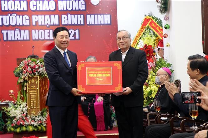 Ủy viên Bộ Chính trị, Phó Thủ tướng Thường trực Chính phủ Phạm Bình Minh tặng quà cho Linh mục tại Tòa giám mục Huế ngày 22/12. (Nguồn: TTXVN)