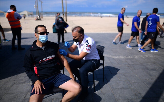 Một người đàn ông được tiêm vaccine Covid-19 tại một trạm tiêm di động trên bãi biển ở Tel Aviv, ngày 20/2. (Nguồn: Times of Israel)