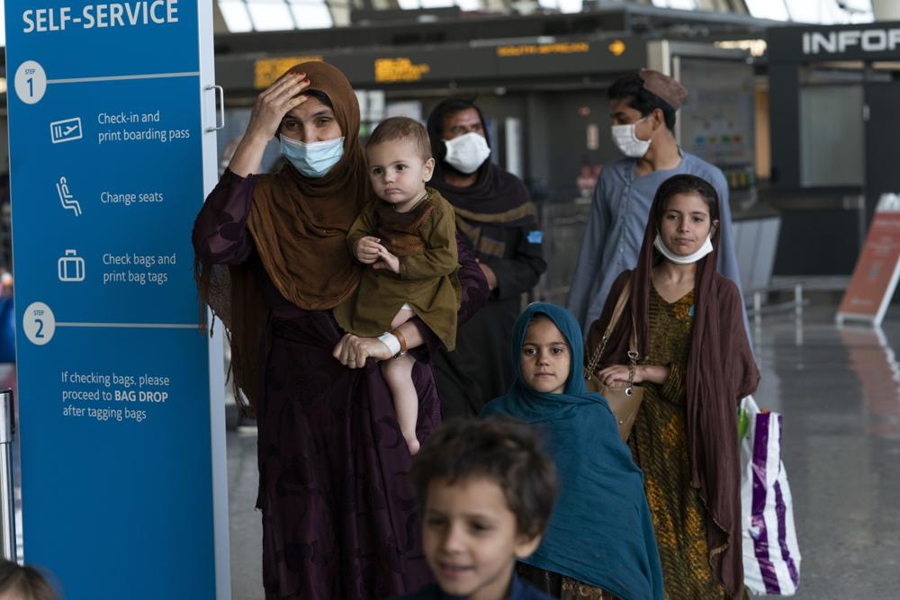 Tổng thống Mỹ khẳng định sẽ tiếp tục chiến dịch không vận dù có nhiều cảnh báo nguy hiểm. Trong ảnh: Các gia đình người Afghanistan từng làm việc cho lực lượng vũ trang Mỹ chuẩn bị được sơ tán khỏi sân bay Kabul ngày 27/8. (Nguồn: AP)