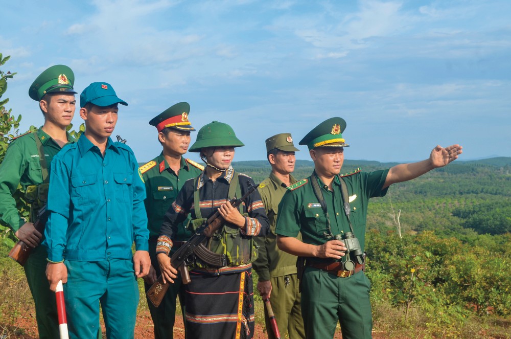 Chiến sỹ đồn biên phòng Ia Nan cùng với người dân tuần tra biên giới. (Ảnh: TGCC) 