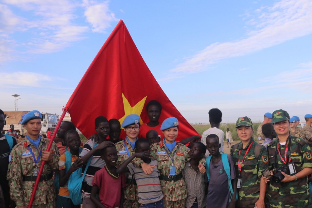 Với Minh Ngọc, khoảnh khắc đáng tự hào nhất là khi các em nhỏ Nam Sudan thi nhau chạm tay vào lá cờ Tổ quốc mà họ mang theo trên đường hành quân.  (Ảnh: NVCC)