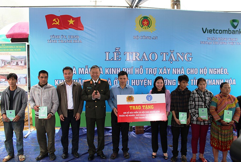 Bộ trưởng Công an và đại diện Bảo hiểm xã hội Việt Nam trao tặng 600 sổ bảo hiểm xã hội cho người dân thuộc hộ nghèo ở huyện Mường Lát, tỉnh Thanh Hóa.