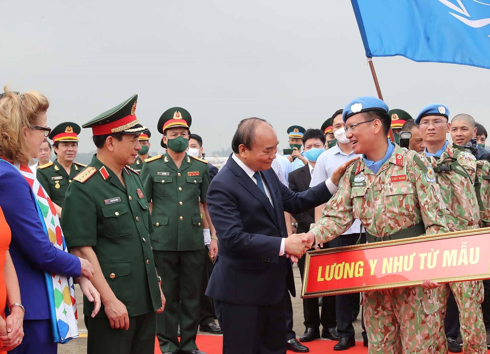 Chủ tịch nước Nguyễn Xuân Phúc và Đại tướng Phan Văn Giang tiễn các sĩ quan Đội Công binh số 1 và Bệnh viện dã chiến cấp 2 số 4 lên đường thực hiện nhiệm vụ. (Nguồn: TTXVN)