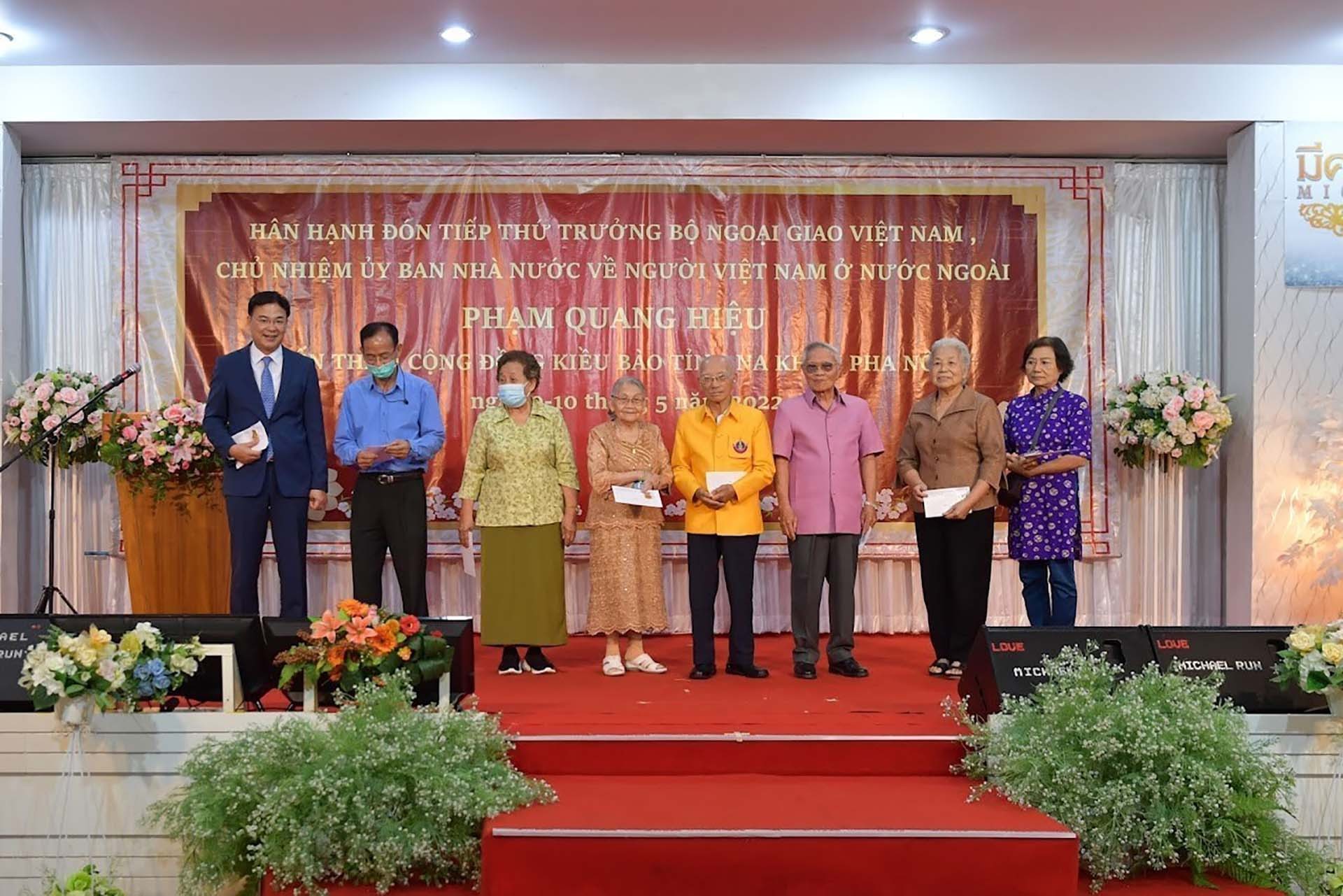 Thứ trưởng Phạm Quang Hiệu (ngoài cùng, trái sang) tặng quà cho các hội đoàn người Việt cùng một số kiều bào có công, kiều bào lão thành. (Nguồn: TTXVN)