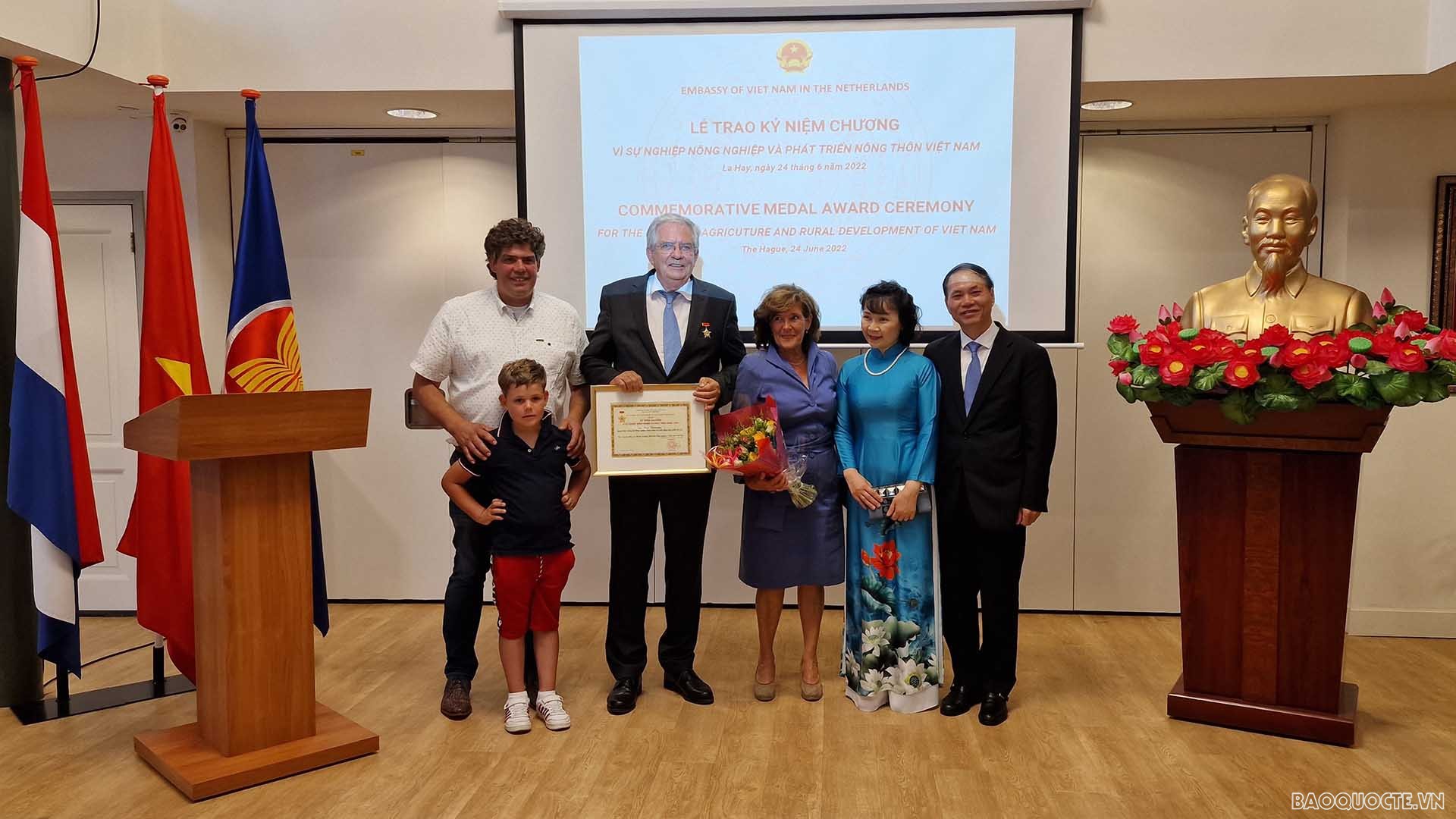 Đại sứ Phạm Việt Anh trao kỷ niệm chương và tặng hoa chúc mừng ông Cees Veerman và gia đình.