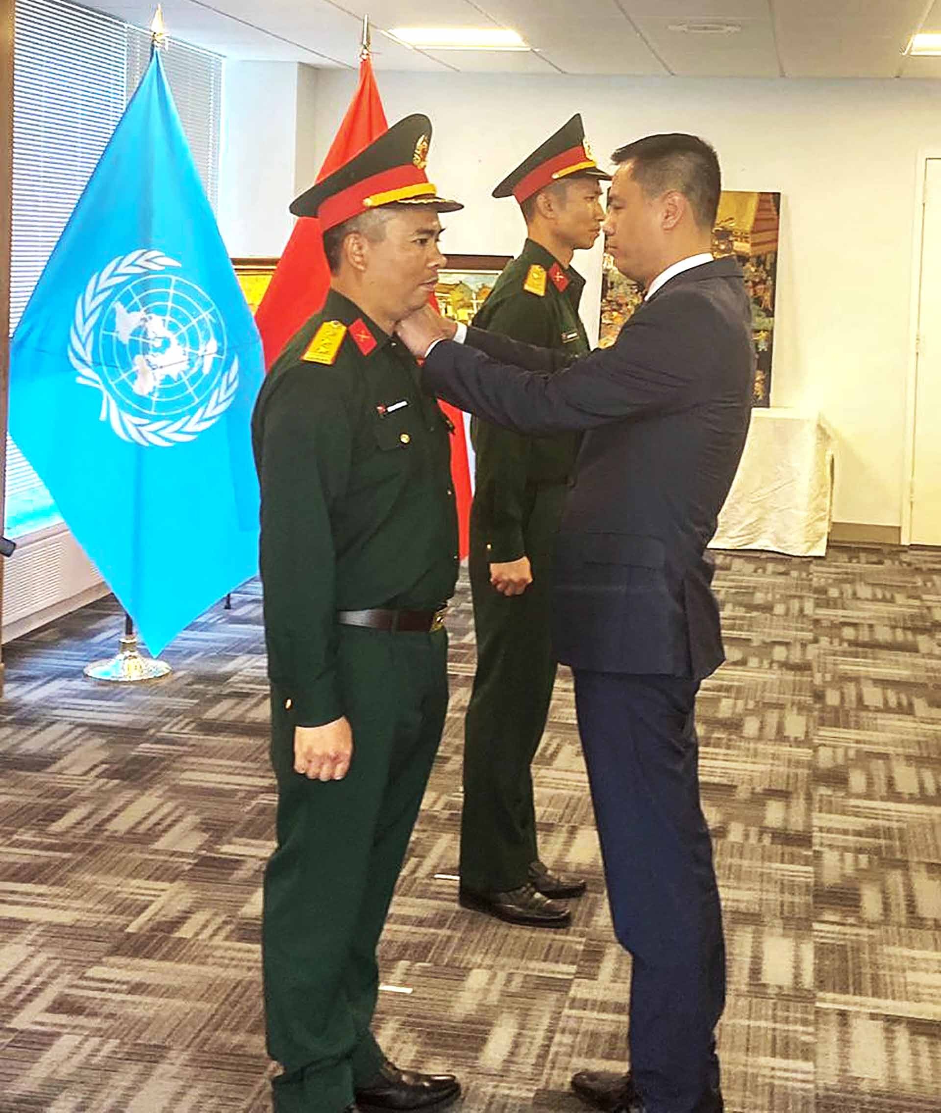 Đại sứ Đặng Hoàng Giang trao quân hàm Thượng tá cho đồng chí Lương Trường Vinh.