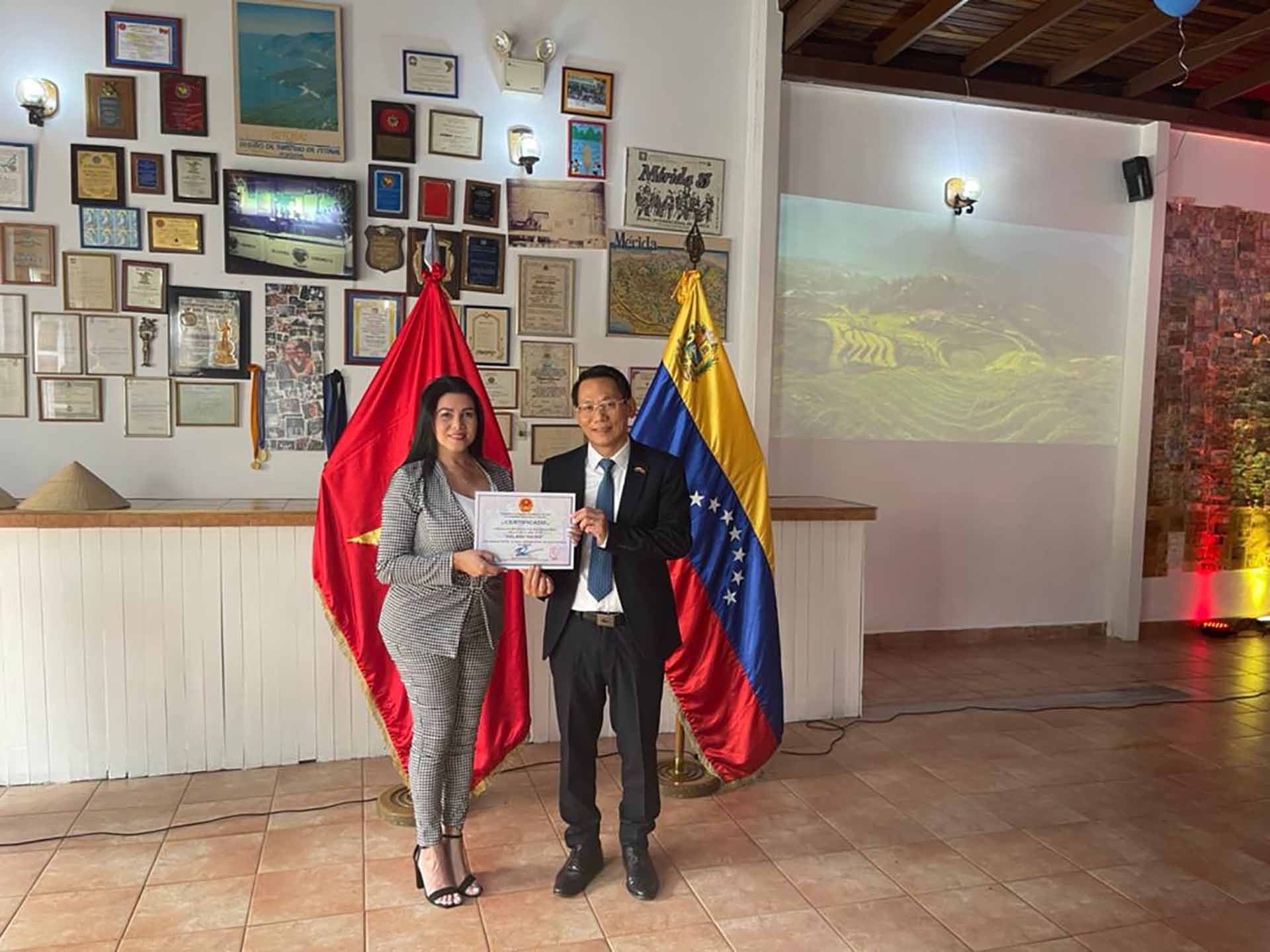 Đại sứ Lê Viết Duyên trao giấy chứng nhận cho chủ cửa hàng kem Isbellis Da Silva.