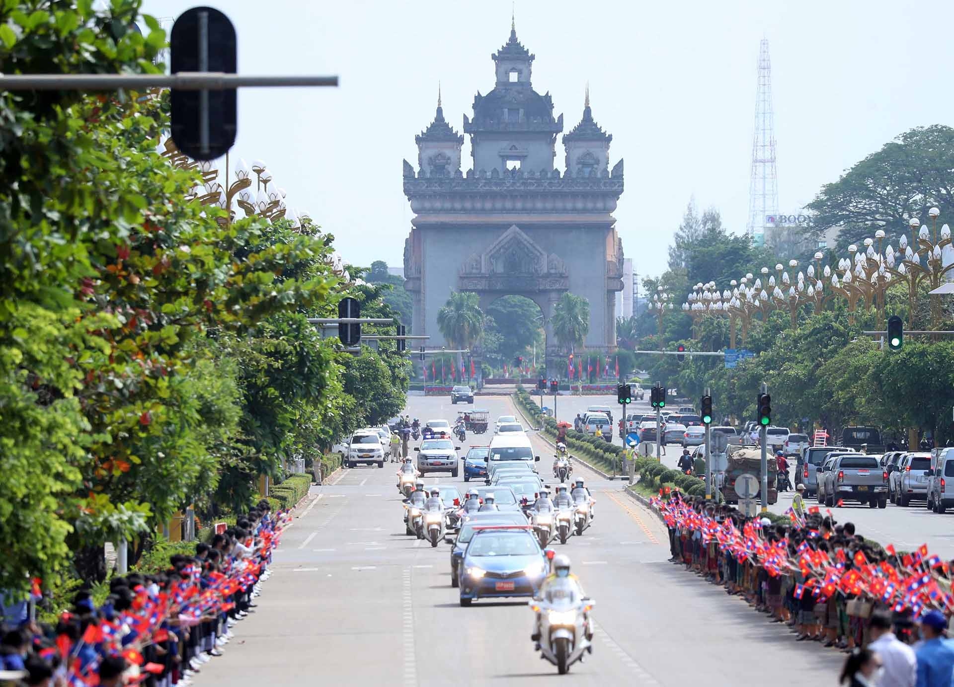 Hàng trăm người dân Thủ đô Vientiane trong những bộ trang phục truyền thống của nhân dân các bộ tộc Lào với cờ hai nước và những bông hoa rực rỡ trên tay đứng dọc 2 bên đại lộ dẫn vào Phủ Chủ tịch, nồng nhiệt chào mừng Chủ tịch nước Nguyễn Xuân Phúc và Phu nhân thăm hữu nghị chính thức Lào.
