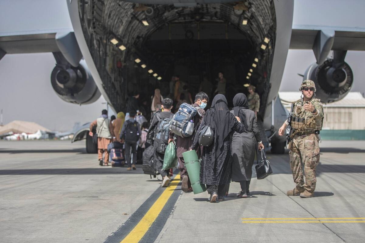 Một đoàn người di tản lên máy bay vận tải C-17 Globemaster của quân đội Mỹ. (Nguồn: AP)