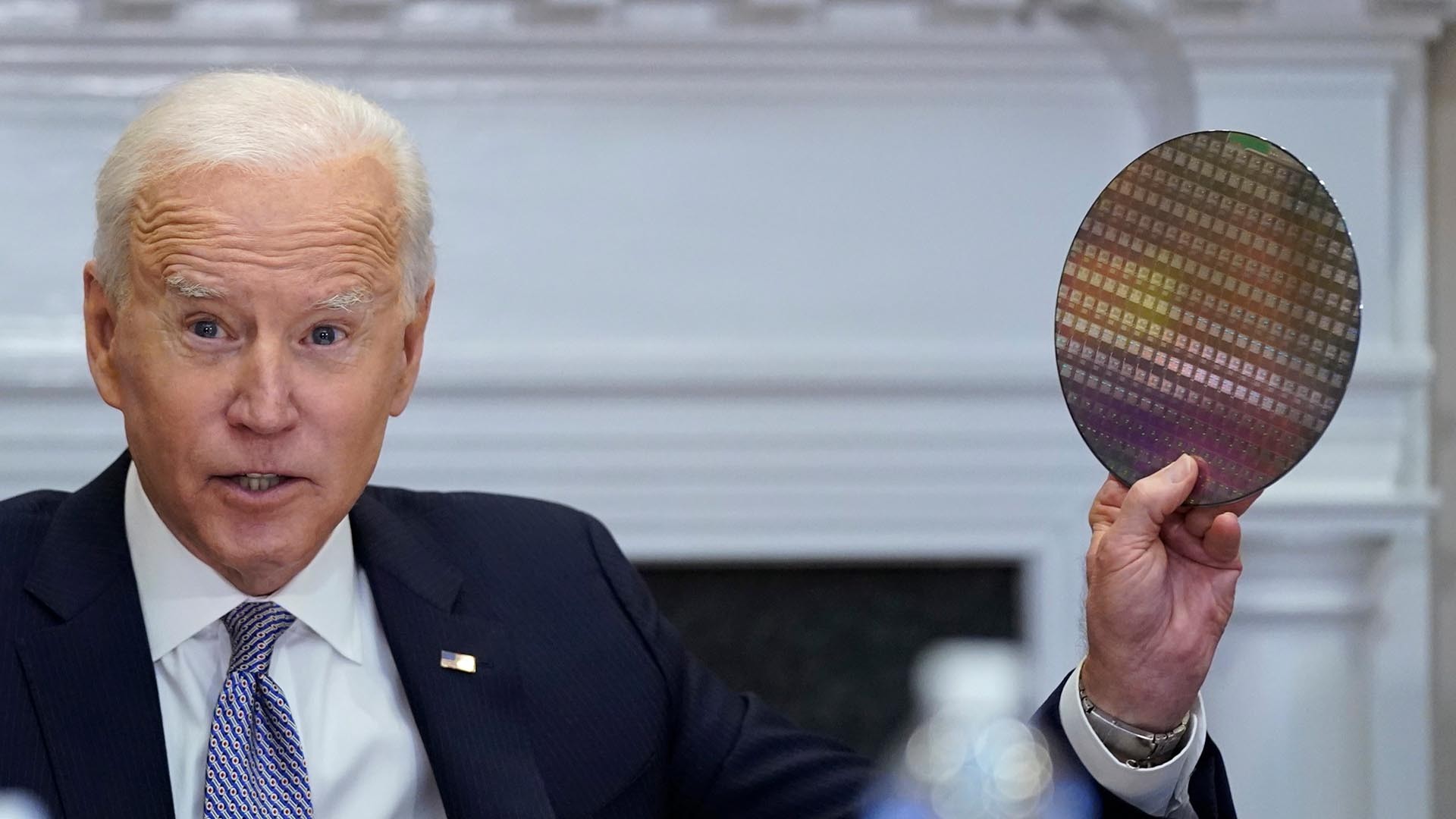 Tổng thống Mỹ Joe Biden cầm một tấm sillicone dùng để sản xuất chip trong cuộc trao đổi với CEO hãng công nghệ lớn tại Mỹ ngày 12/4. (Nguồn: AP)