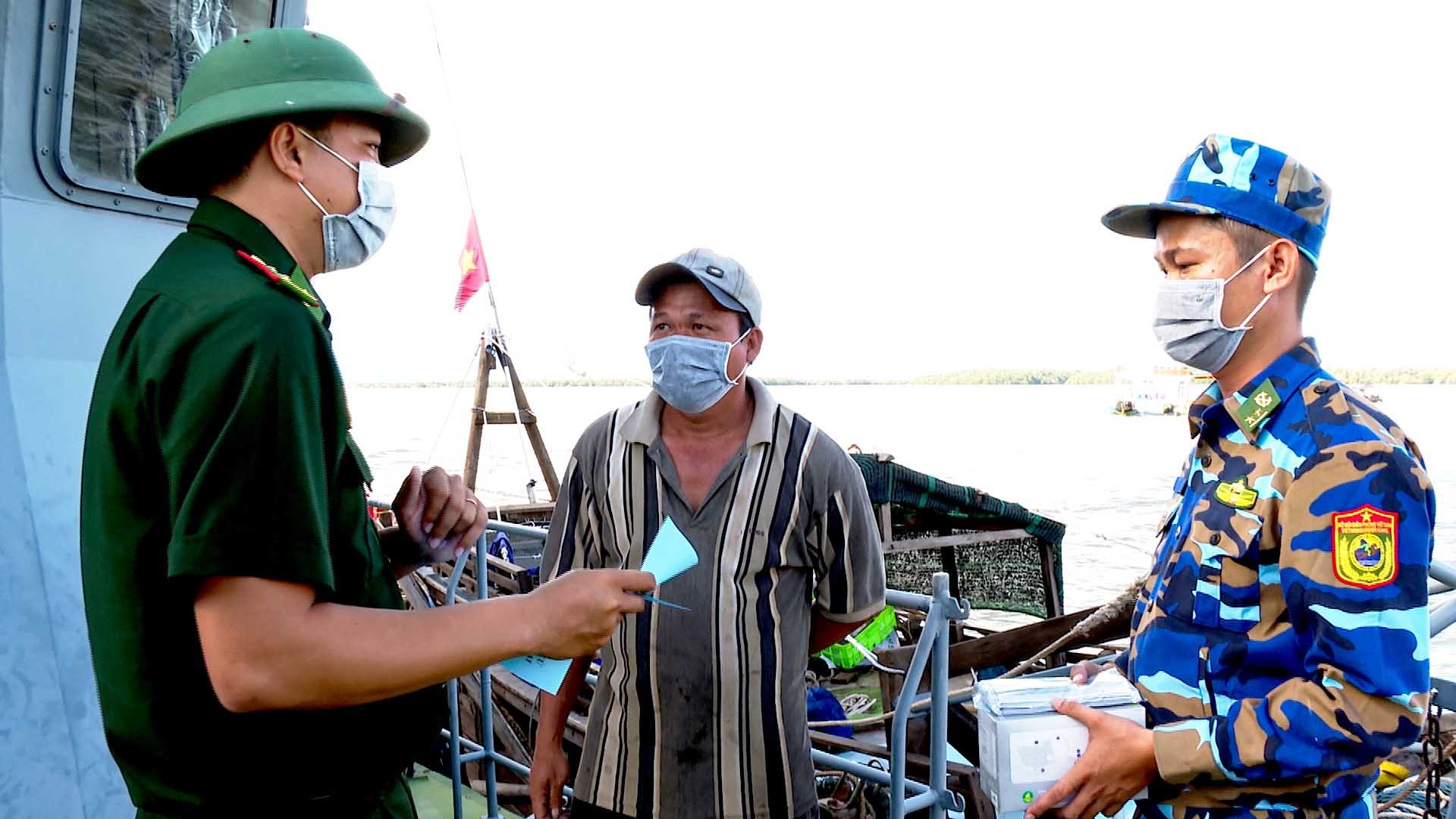 BĐBP Sóc Trăng phát tờ rơi tuyên truyền cho ngư dân về các quy định chống khai thác hải sản bất hợp pháp. (Ảnh: Văn Long-Chiến Khu)