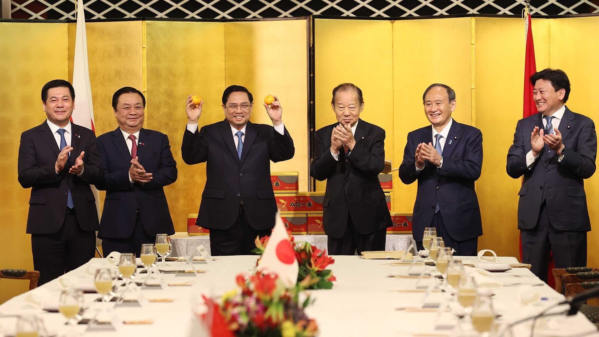 Thủ tướng Phạm Minh Chính và cựu Thủ tướng Nhật Bản Suga Yoshihide và Chủ tịch Liên minh Nghị sỹ Hữu nghị Nhật-Việt Nikai Toshihiro, và dự Lễ xuất hành quả quýt Unshu sang thị trưởng Việt Nam. (Nguồn: TTXVN)