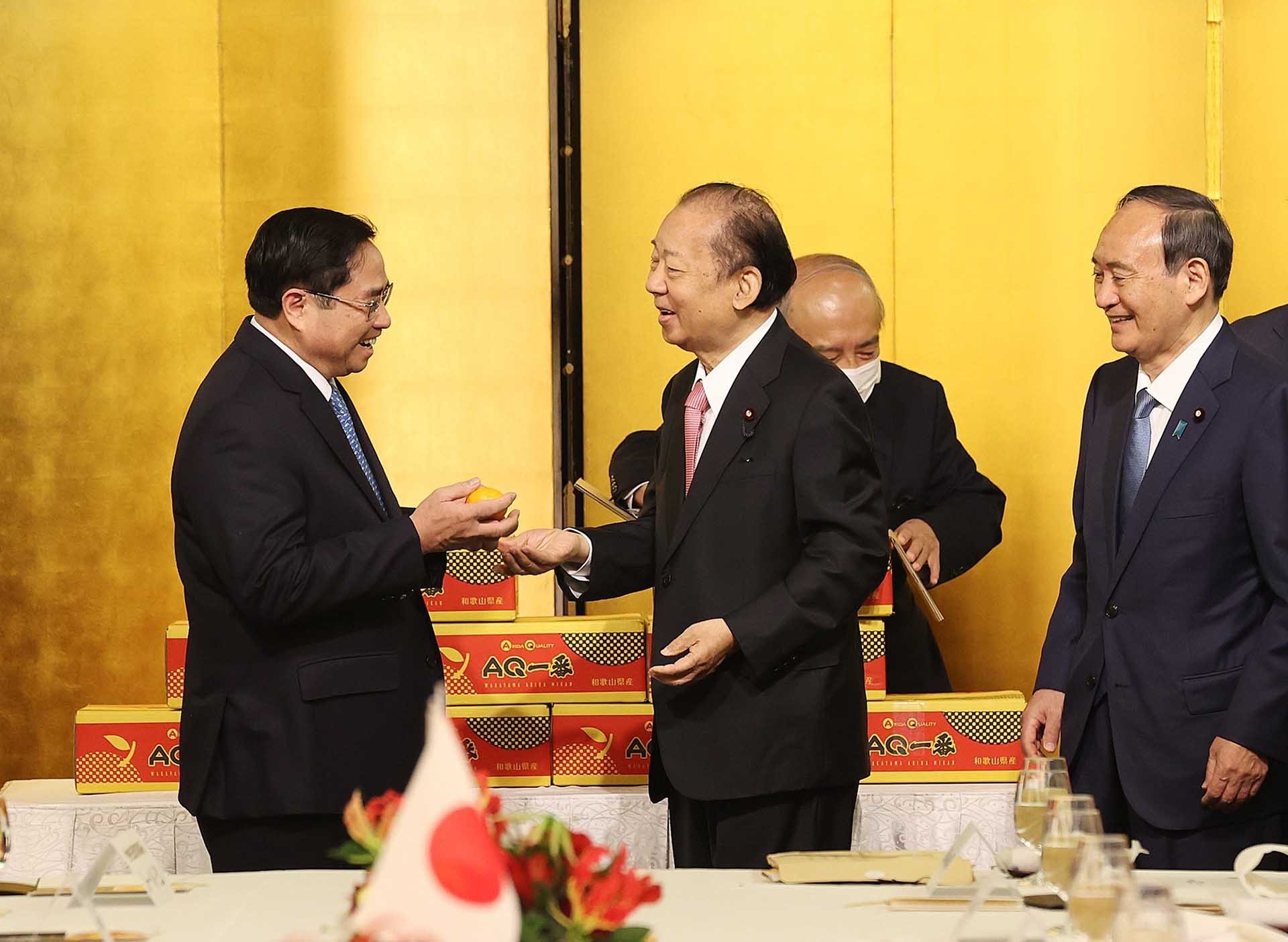 Chủ tịch Liên minh Nghị sỹ Hữu nghị Nhật-Việt Nikai Toshihiro tặng quýt Unshu cho Thủ tướng Phạm Minh Chính. (Nguồn: TTXVN)