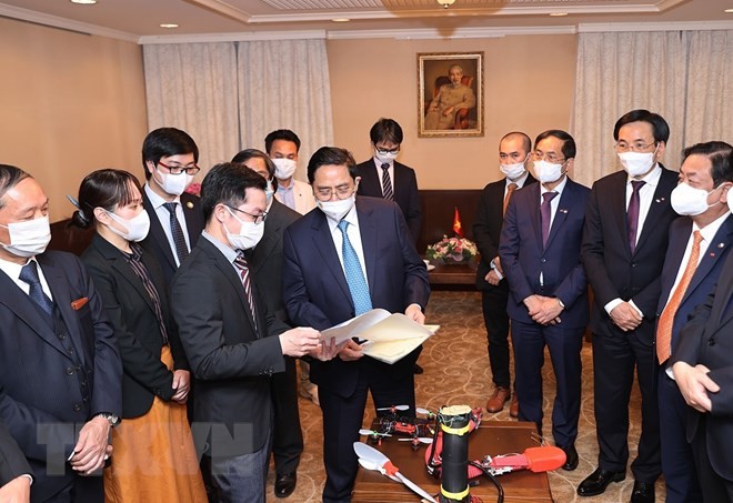 Thủ tướng Phạm Minh Chính xem các sáng chế công nghệ của trí thức Việt Nam tại Nhật Bản. (Nguồn: TTXVN)