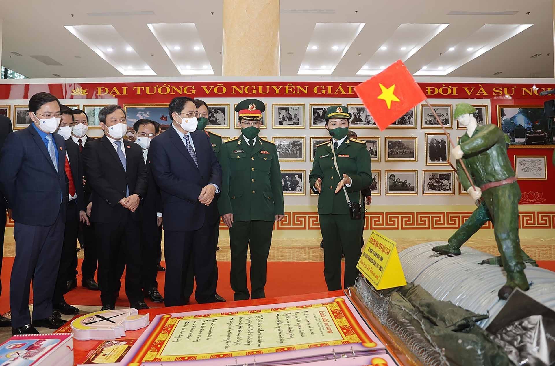 Thủ tướng Phạm Minh Chính và các đại biểu tham quan trưng bày ảnh và tư liệu về Đại tướng Võ Nguyên Giáp. (Nguồn: TTXVN)