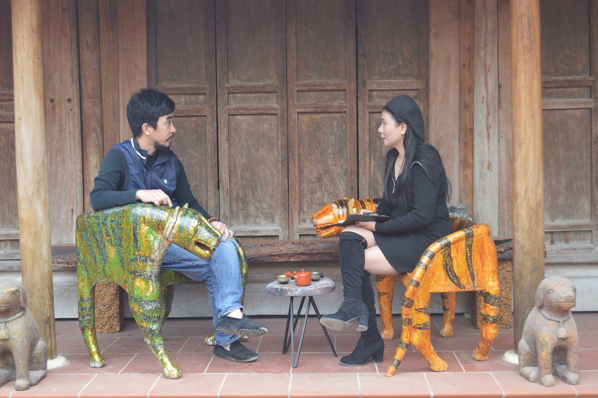 Họa sĩ, nghệ nhân Nguyễn Tấn Phát (trái) trao đổi với phóng viên về nghệ thuật sơn mài truyền thống và những tạo tác mới về hổ. (Ảnh: Nguyễn Mạnh Cường)