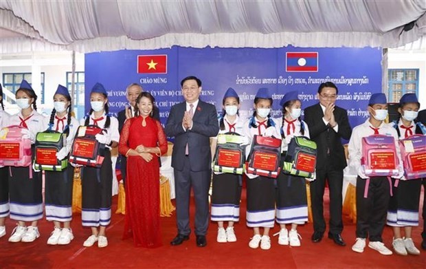 National Assembly Chairman Vuong Dinh Hue presents gifts to outstanding students at Ethnic Minority Boarding School in Champasak province of Laos on May 17. (Photo: VNA)