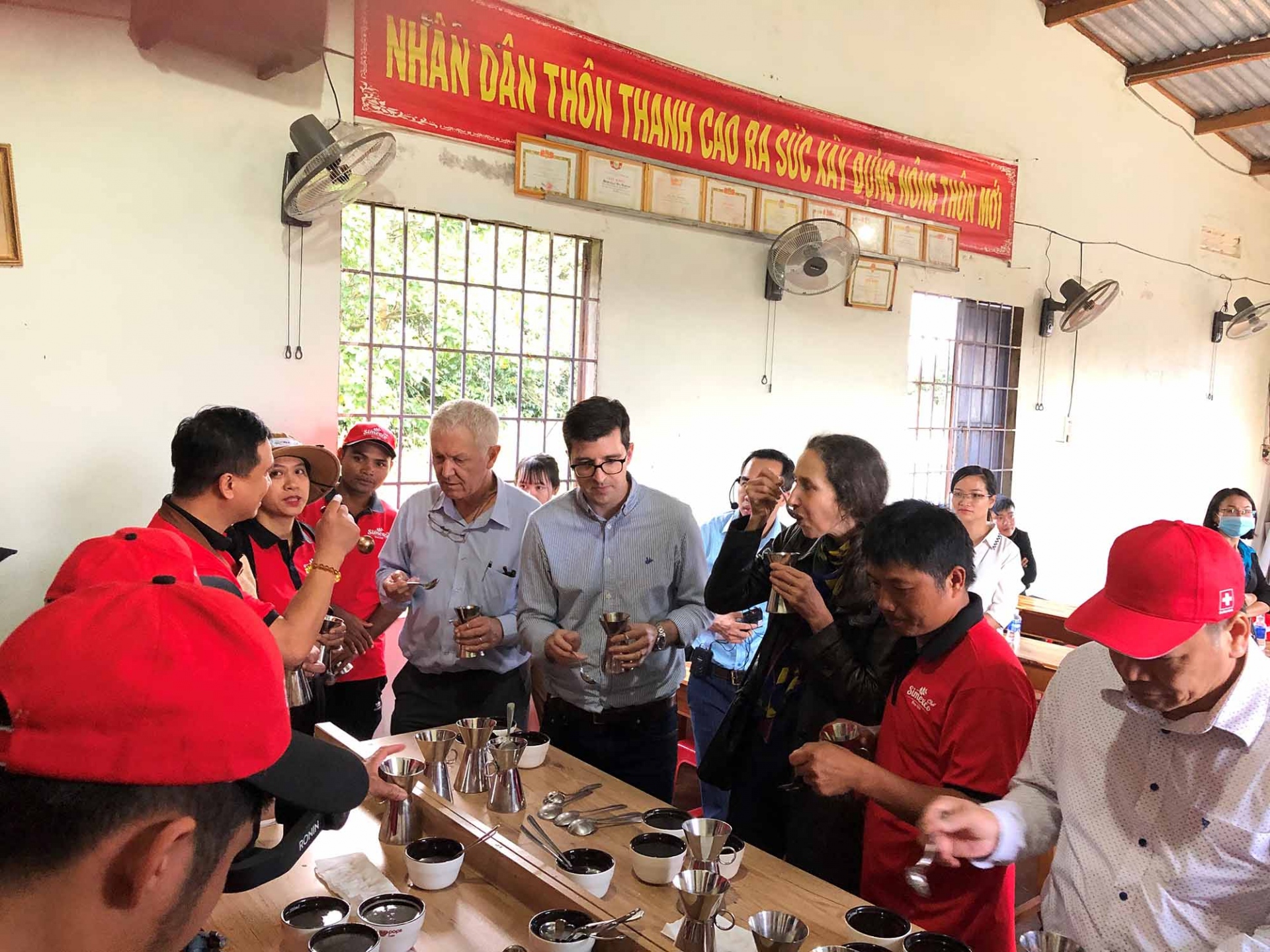 Đại sứ Thụy Sỹ và nhân viên Đại sứ quán cùng thưởng thức cà phê với những người nông dân địa phương tại huyện Krông Năng, tỉnh Đắk Lắk. Đây là những nông dân đã tham gia vào dự án sản xuất cà phê bền vững do Thụy Sỹ tại trợ.