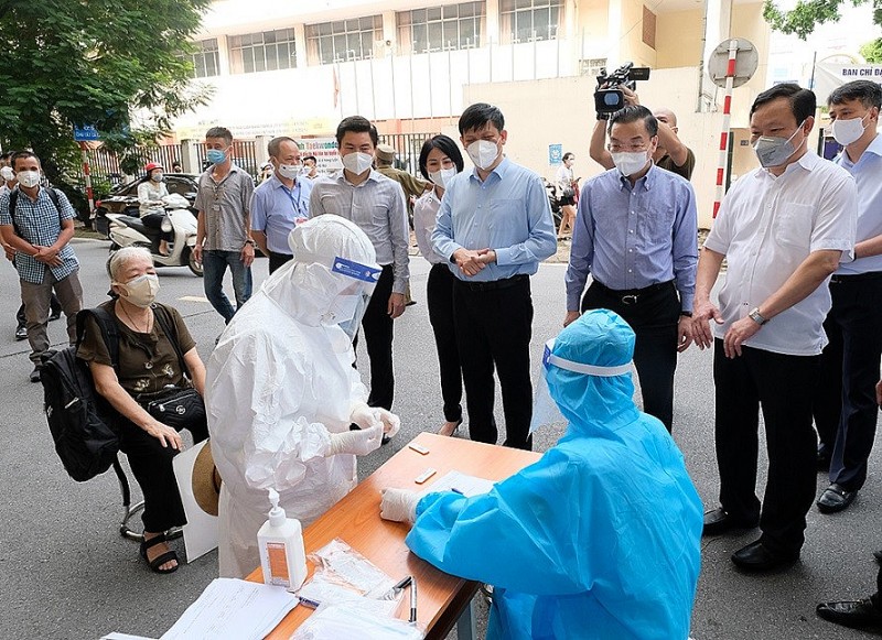 Bộ trưởng Bộ Y tế Nguyễn Thanh Long chứng kiến cán bộ y tế đang tiến hành xét nghiệm tầm soát cho người đến tiêm chủng tại điểm tiêm chủng vaccine COVID-19 trên phố Trịnh Hoài Đức (Hà Nội) sáng ngày 10/9. (Ảnh: Trần Minh)