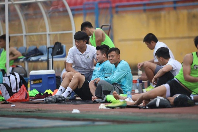 Quang Hải (thứ hai từ trái sang) ngồi theo dõi trận đấu của FC Hà Nội (Ảnh: Hoàng Quốc).