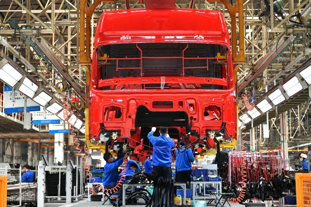 Công nhân làm việc tại dây chuyền sản xuất xe tải hạng nặng của Tập đoàn sản xuất ô tô Thiểm Tây, Trung Quốc
