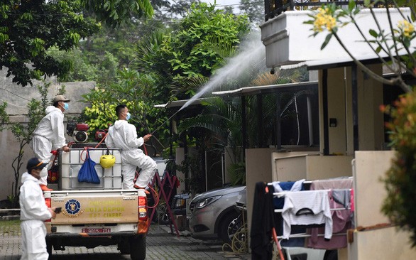 Nhân viên xịt hóa chất sát khuẩn ở ngoại ô Jakarta (Indonesia) vào ngày 7-7-2021 - Ảnh: REUTERS