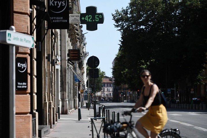 Người dân địa phương đi ngang qua một hiệu thuốc có bảng hiển thị nhiệt độ ngoài trời 42,5 độ C ở Toulouse, miền nam nước Pháp, ngày 17/7.