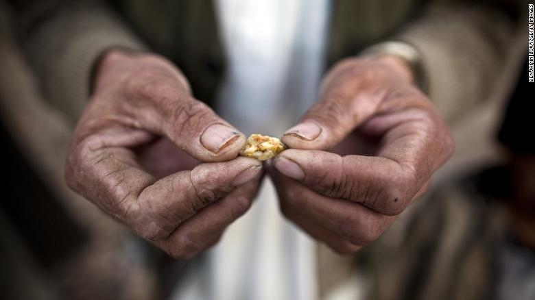 Một người đàn ông Afghanistan cầm một cục vàng nhỏ