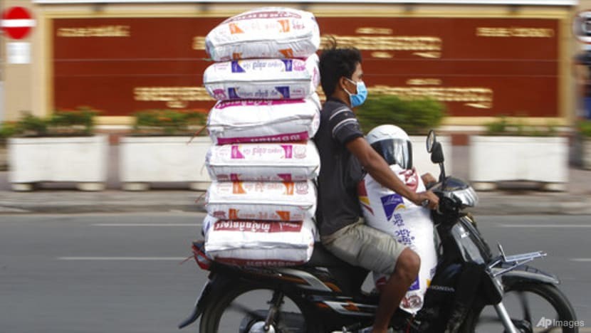 Một người đi xe máy chở những bao gạo trên ghế sau đến chợ ở Phnom Penh, Campuchia. (Nguồn: AP)