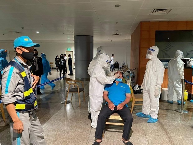 A worker at Tan Son Nhat International Airport has his sample taken for COVID-19 testing (Photo: VNA)