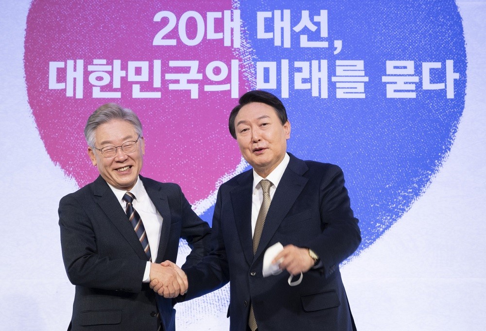(03.08) Ứng cử viên tổng thống Hàn Quốc Yoon Suk-yeol và đối thủ Lee Jae-myung bắt tay tại một sự kiện hồi tháng 11/2021. (Nguồn: YNA)