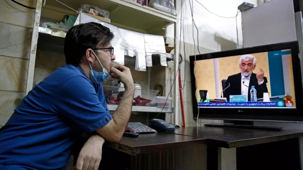 (06.08) Một người dân theo dõi cuộc tranh luận trực tiếp trên truyền hình giữa các ứng viên Tổng thống Iran ngày 5/6. (Nguồn: AFP)