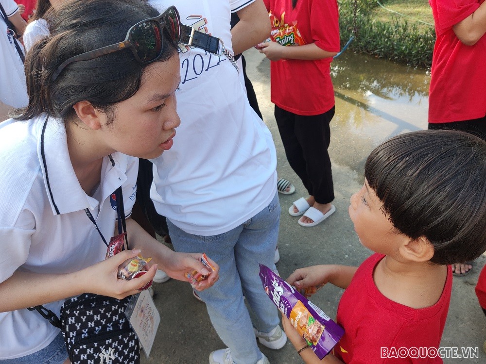 (07.21) Thanh niên, kiều bào trẻ trò chuyện, tặng kẹo cho các trẻ em tại Làng trẻ em SOS Vinh. (Ảnh: Minh Quân)