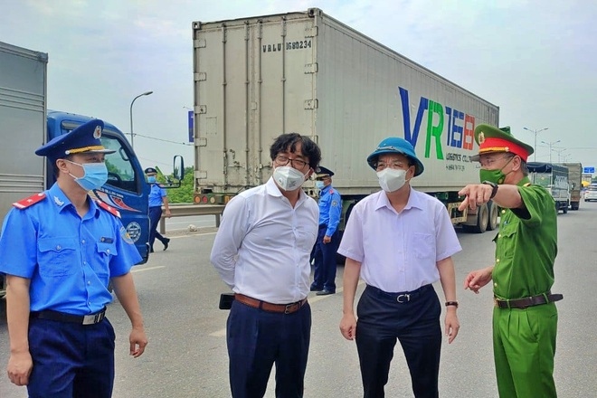Chủ tịch UBND TP Hà Nội Chu Ngọc Anh (thứ 2, bên phải) chỉ đạo các phương án thông luồng, tạo thuận lợi cho phương tiện chở hàng hóa lưu thông qua thủ đô (Ảnh: Thành Trung).