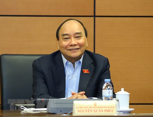 Chủ tịch nước Nguyễn Xuân Phúc, đại biểu Quốc hội Thành phố Hồ Chí Minh thảo luận ở tổ. (Ảnh: Văn Điệp/TTXVN)
