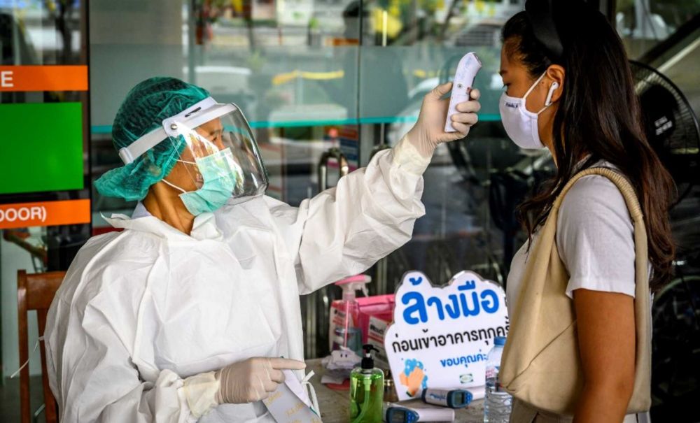 Nhân viên y tế kiểm tra thân nhiệt phòng lây nhiễm COVID-19 tại Bangkok, Thái Lan, ngày 24/4. (Nguồn: AFP)